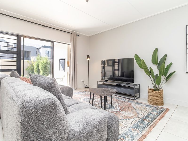 A bright and modern living room featuring large sliding glass doors that provide seamless access to the outdoor patio area.