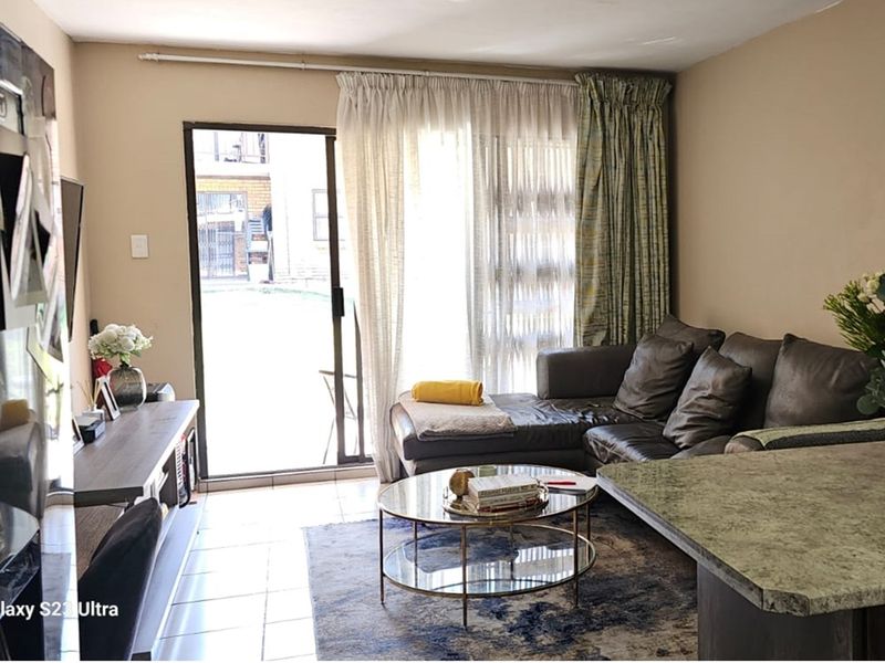Open plan living area featuring tiled flooring and a sliding glass door providing access to the outdoor patio space.