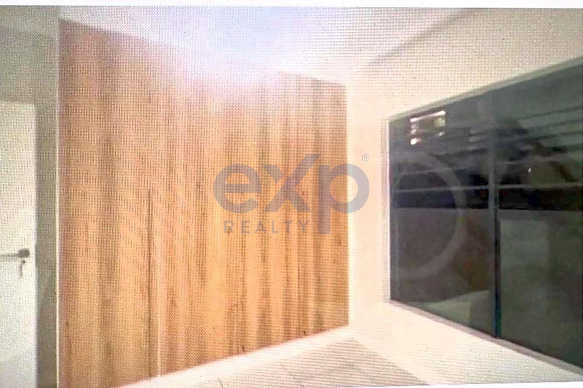A bedroom featuring built-in wooden cabinetry and a large window, providing a clean and functional living space.