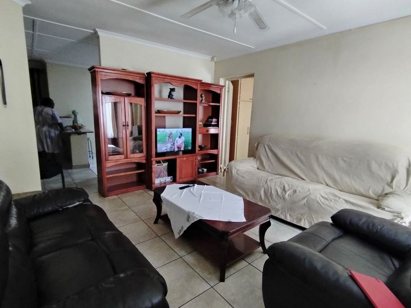 A functional living room featuring tiled flooring and a ceiling fan, providing a comfortable and practical space for relaxation.