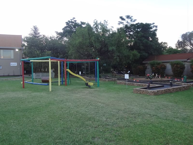 Spacious lodge garden featuring a children's playground, miniature golf course, and well-maintained lawn area adjacent to the main lodge buildings.