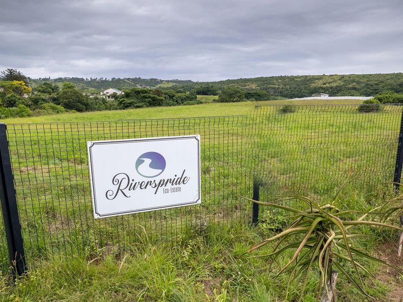 A view of the vacant residential land at Riverspride Eco-Estate, featuring secure wire mesh perimeter fencing and surrounding natural landscape.