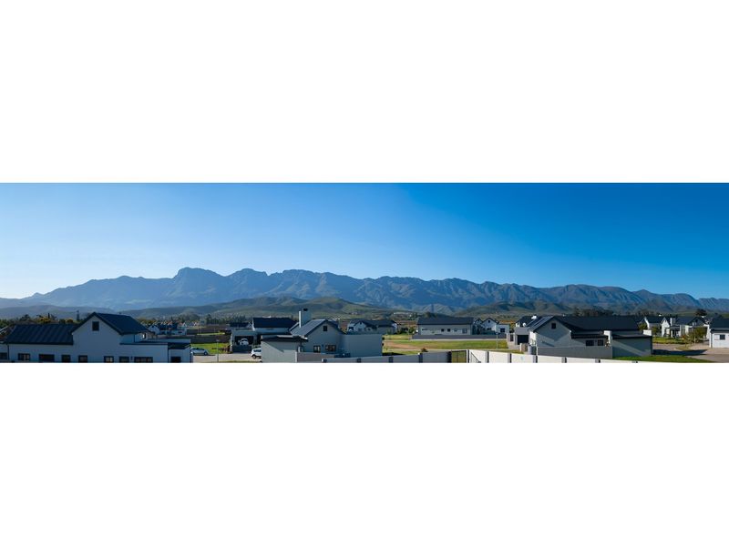 Panoramic view of the surrounding residential estate with a prominent mountain range backdrop.