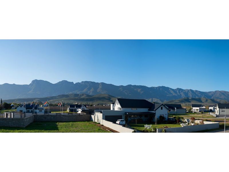 Panoramic view of the residential estate featuring well-maintained properties set against a scenic mountain backdrop.