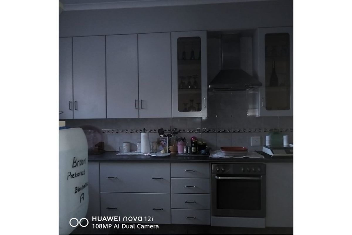 A functional kitchen featuring built-in cabinetry, a tiled backsplash, and integrated oven with extractor fan.