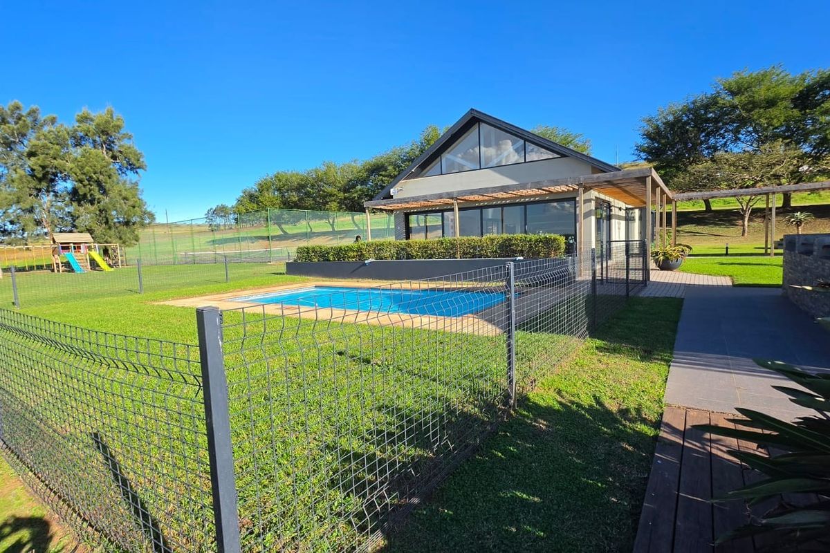 Rear exterior view featuring a swimming pool, timber pergola, and well-maintained garden area with a modern pitched roof structure.
