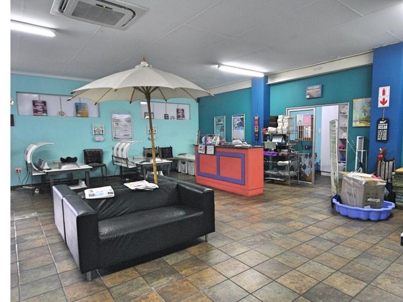 Commercial reception and waiting area featuring tiled flooring, recessed ceiling lighting, and a built-in service counter.