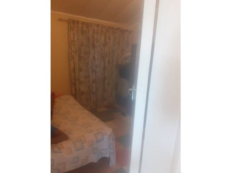 A view into a bedroom featuring a curtained window and basic interior finishes.
