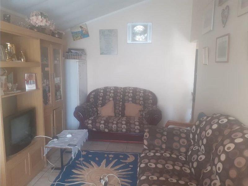 A living room area featuring tiled flooring and a sloped ceiling, providing a functional space for relaxation.