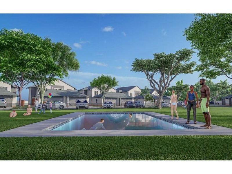 A communal swimming pool area set within a landscaped residential estate, featuring a paved surround and surrounding lawn.