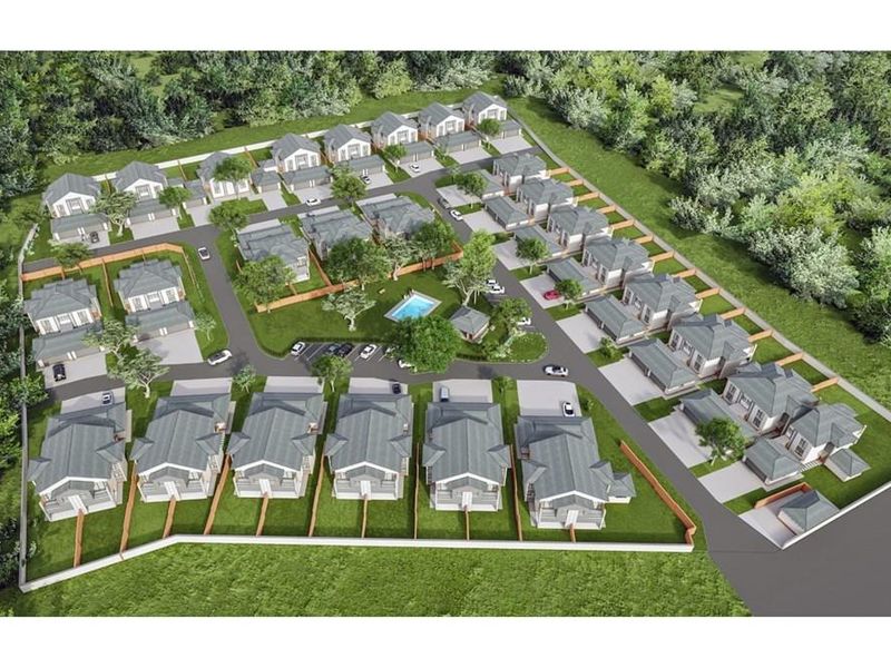 An aerial view of a residential townhouse development featuring multiple units, paved driveways, landscaped gardens, and a communal swimming pool.
