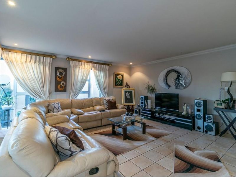 Spacious living room featuring ceramic floor tiles, recessed downlighting, and large sliding glass doors providing access to the exterior.