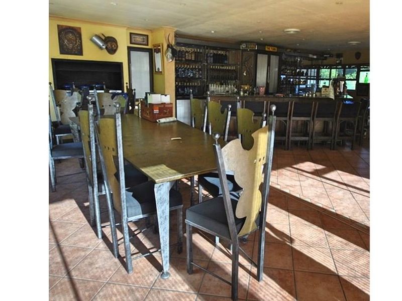 A spacious bar area featuring a built-in service counter, tiled flooring, and recessed ceiling lighting, suitable for entertaining.