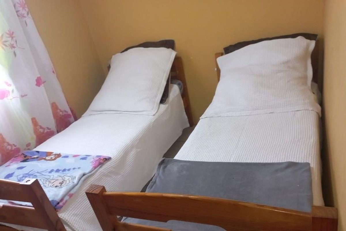 A compact bedroom featuring two single beds, suitable for a guest room or children's bedroom.