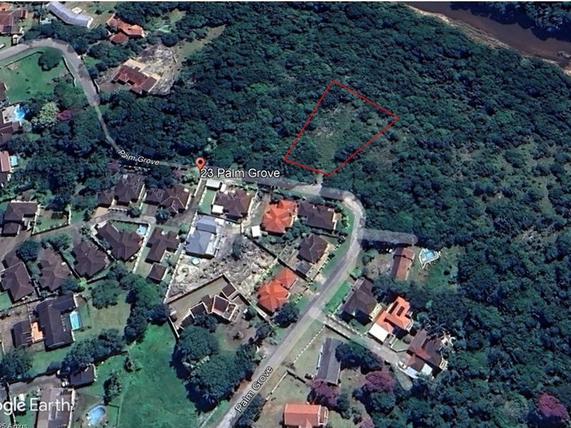 Aerial view of a vacant residential land plot located in a established neighborhood, surrounded by dense vegetation and existing residential properties.