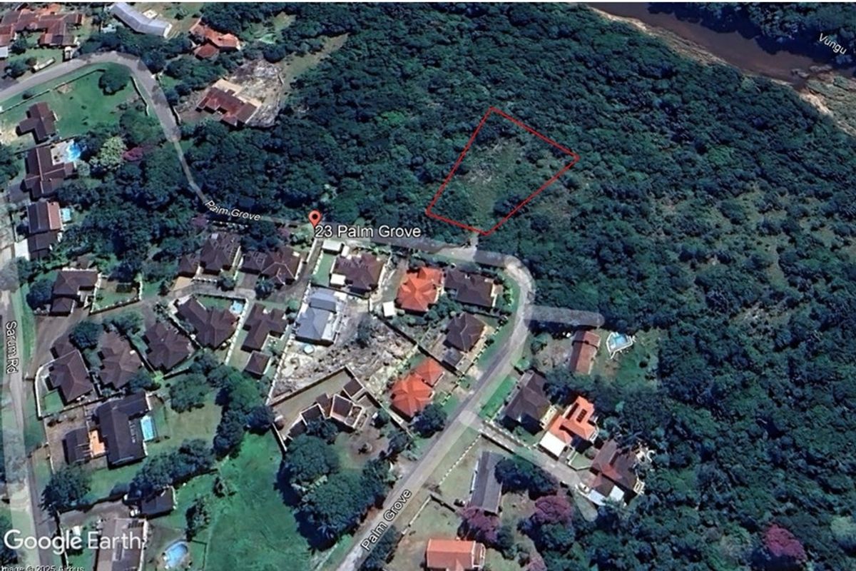 Aerial view of a vacant residential land plot located in a established neighborhood, surrounded by dense vegetation and existing residential properties.