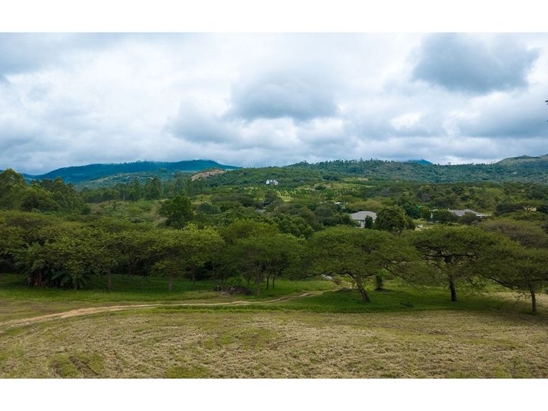 Expansive elevated view of the surrounding natural landscape, rolling hills, and lush greenery characteristic of the small holding property.