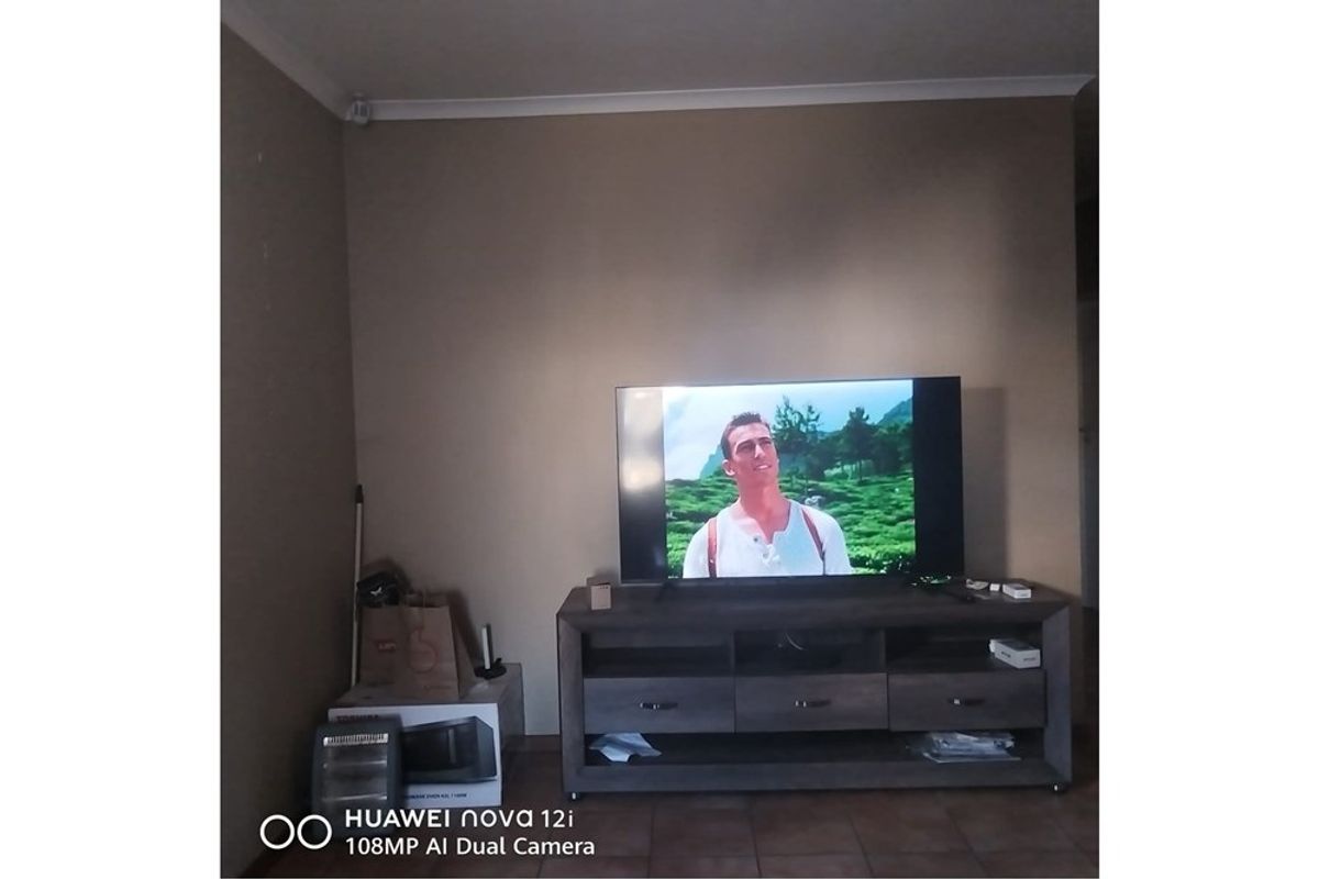 A living room area featuring tiled flooring and neutral wall finishes, providing a functional space for entertainment.