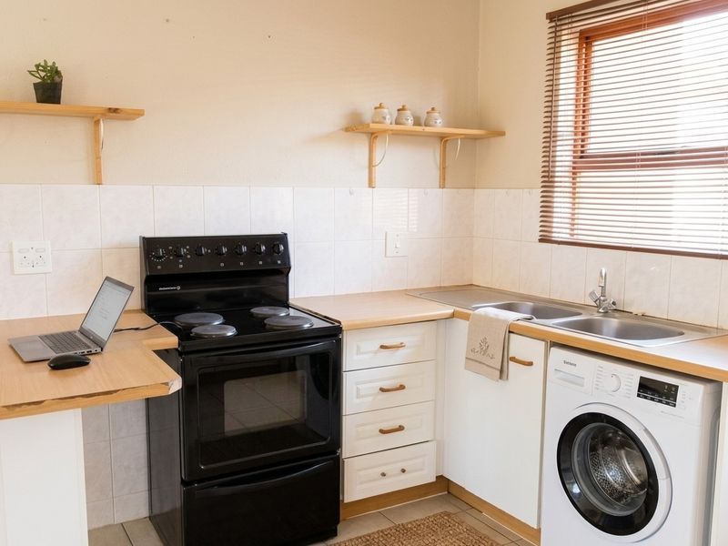 A functional kitchen featuring laminate countertops, a built-in electric stove and oven, double sink, and tiled backsplash with ample cabinetry.