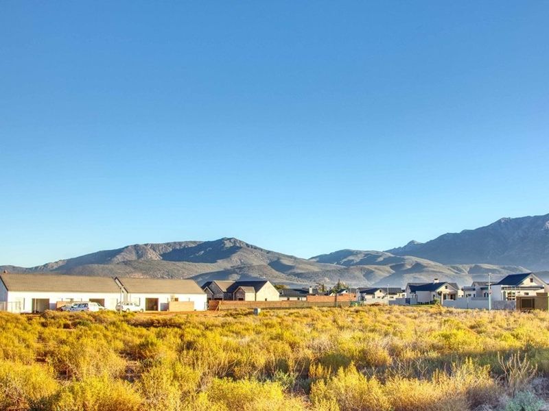 A scenic view of the surrounding landscape and mountain range from the vacant residential plot.