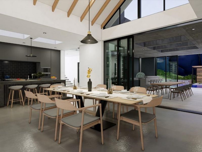Modern open-plan living and dining area featuring high vaulted ceilings, sleek kitchen cabinetry, and seamless indoor-outdoor flow to a covered patio and pool.