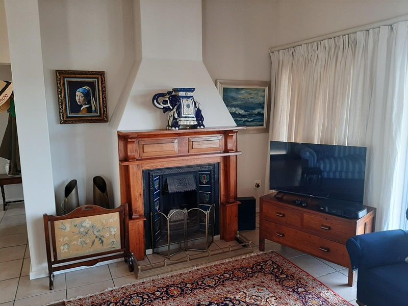 A cozy living room featuring a traditional wooden fireplace mantelpiece and tiled flooring, providing a warm and classic focal point for the space.