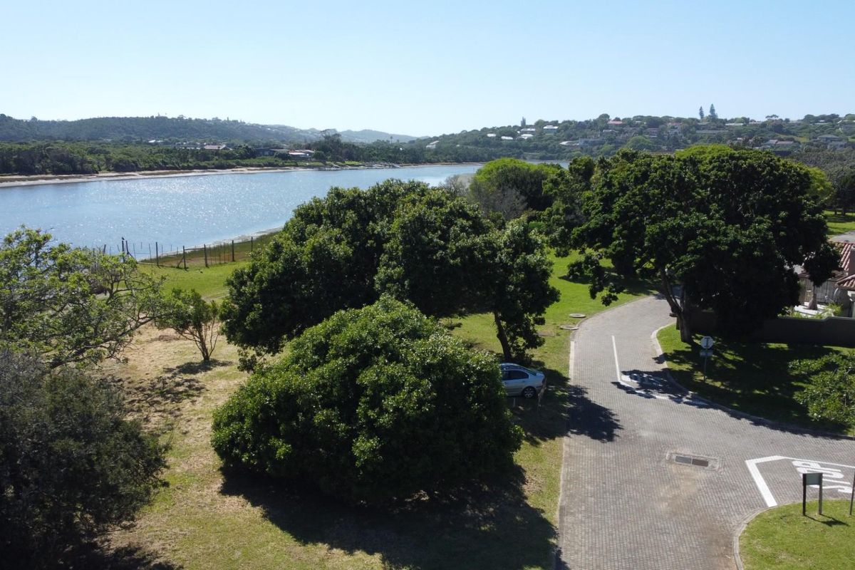 Aerial view of the residential land parcel featuring established trees, paved access road, and scenic views overlooking the nearby river and surrounding landscape.
