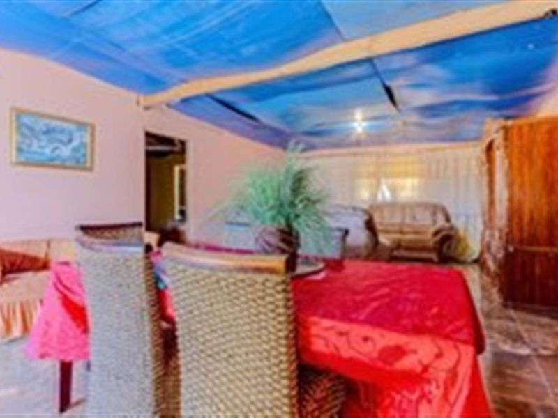 Living area featuring tiled flooring and a damaged ceiling requiring repair or replacement.