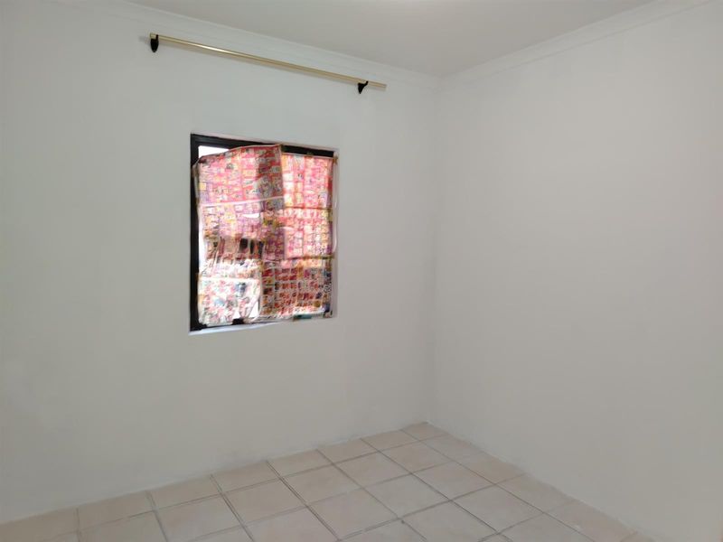 A clean, empty bedroom featuring neutral white walls, tiled flooring, and a curtain rod, ready for personalization.