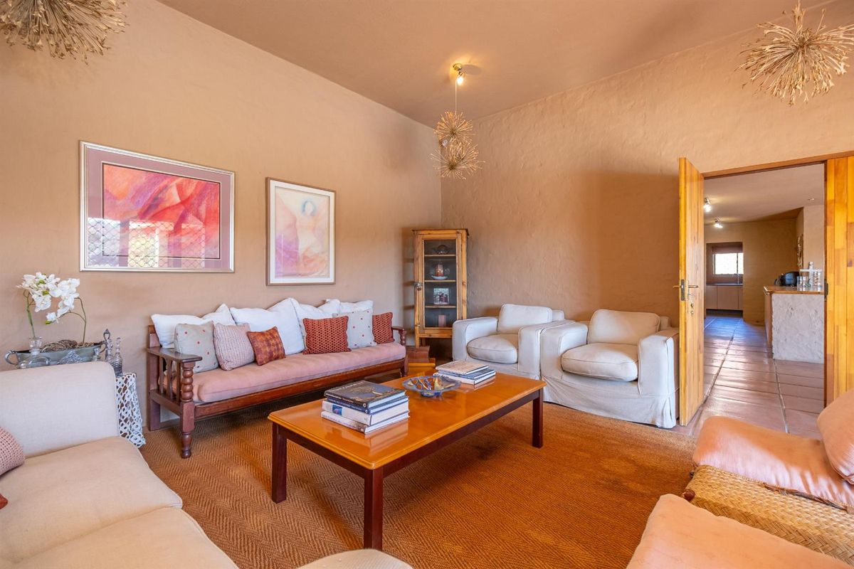 A cozy living room featuring textured walls, tiled flooring, and a doorway leading to an adjacent kitchen area.