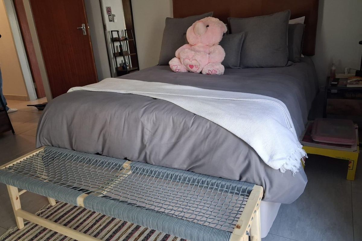 A comfortable bedroom featuring tiled flooring and a built-in door, providing a functional and neutral space for rest.