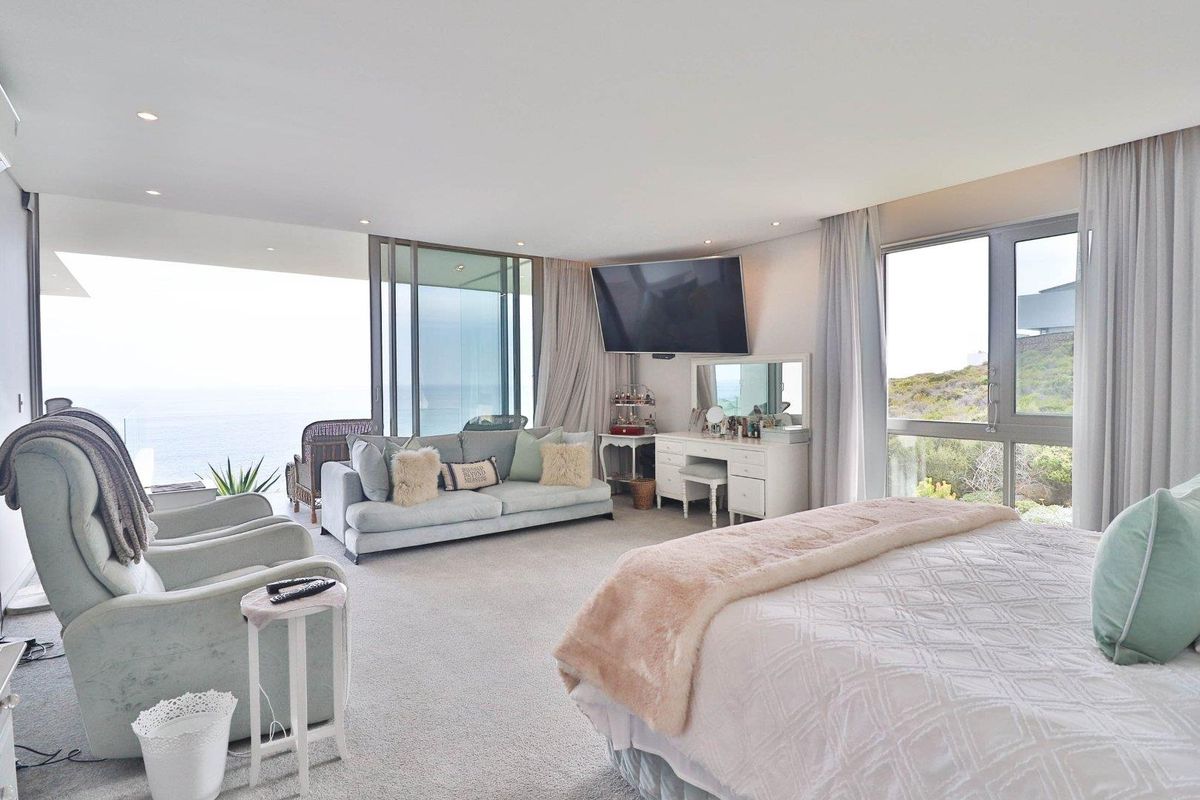 Spacious bedroom featuring large sliding glass doors that open to a private balcony with expansive ocean views and integrated recessed lighting.