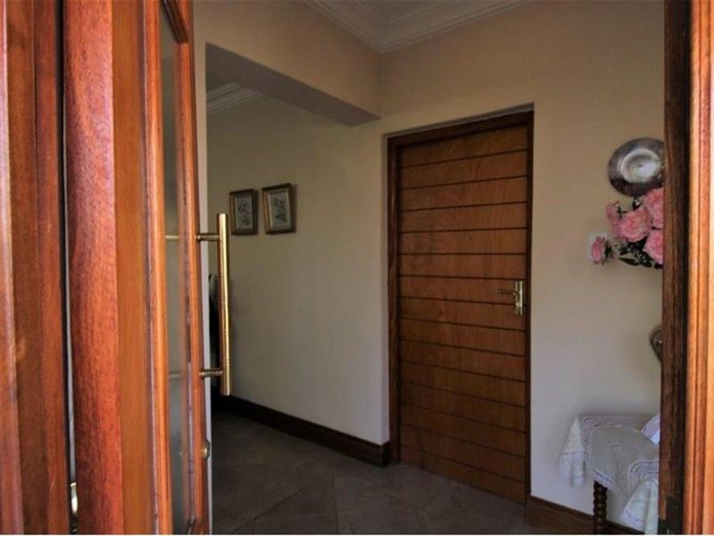 A welcoming entrance hall featuring solid timber doors, tiled flooring, and classic architectural detailing, providing a warm transition into the home's interior spaces.