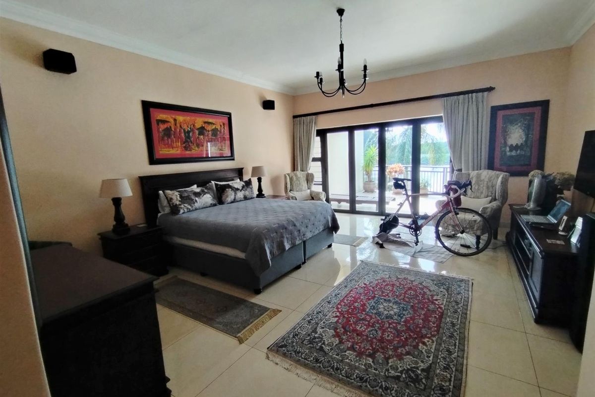 Spacious bedroom featuring large sliding glass doors that open onto a private balcony, providing natural light and access to outdoor space.