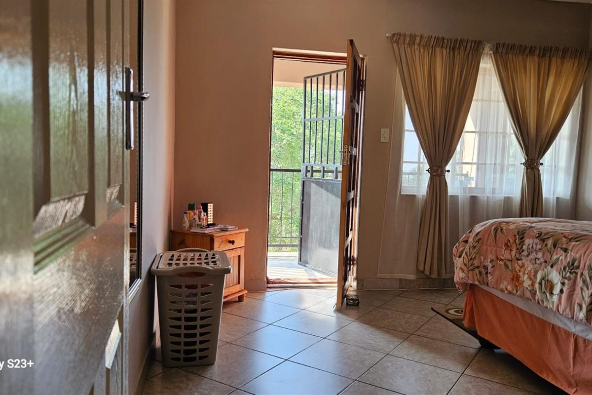 A bedroom featuring tiled flooring and a door providing direct access to an outdoor balcony area.