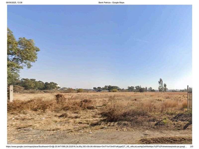 A vacant industrial plot featuring undeveloped land with sparse vegetation and perimeter fencing posts.