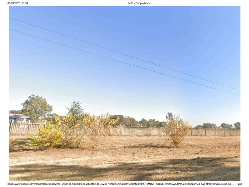 A view of the rear property boundary featuring perimeter fencing and open land.