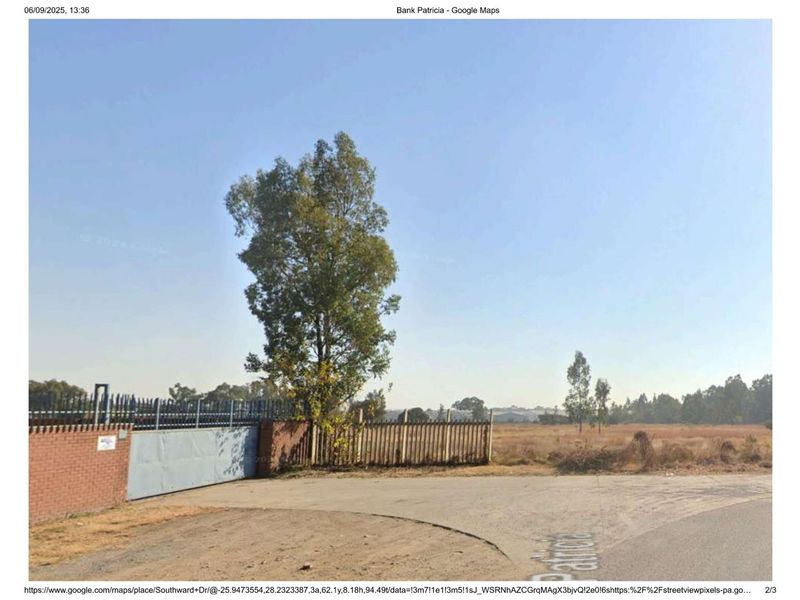 Street view of an industrial property entrance featuring a brick boundary wall, steel security gate, and palisade fencing.