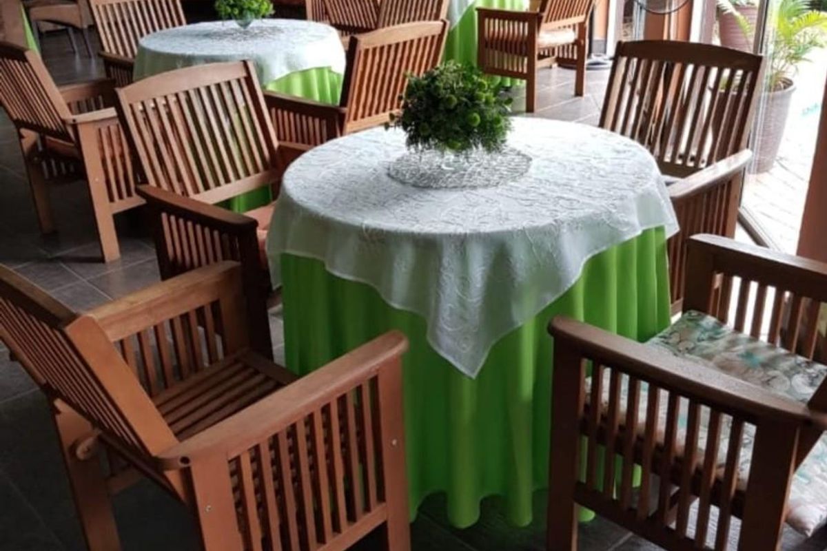 A spacious indoor dining or entertainment area featuring tiled flooring, large glass sliding doors, and warm-toned walls, suitable for hosting guests.