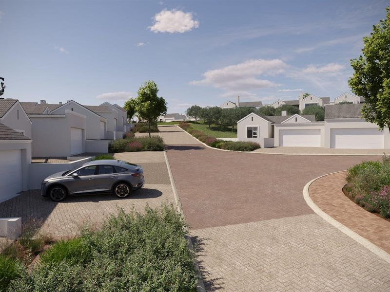 A view of a modern residential street featuring paved driveways, garage access, and well-maintained landscaped surroundings in a quiet estate setting.