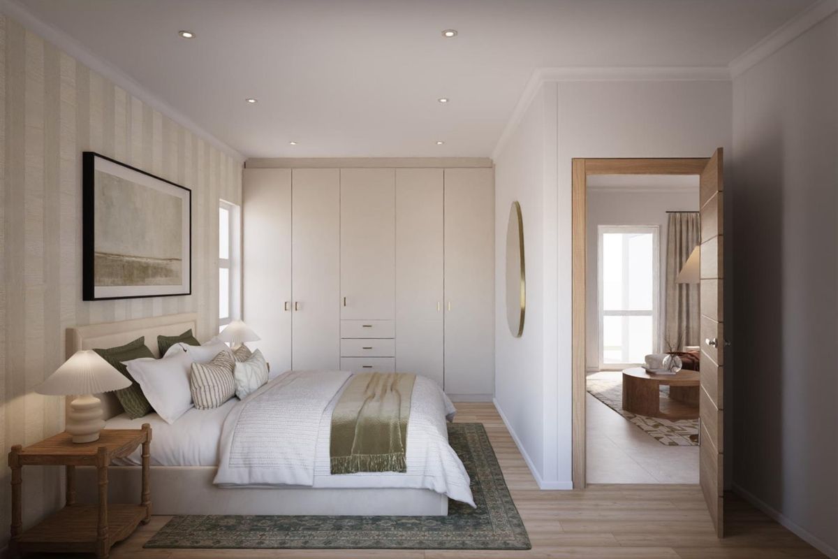 A well-appointed bedroom featuring built-in wardrobes, recessed downlighting, and light timber flooring, with a view into an adjacent living space.