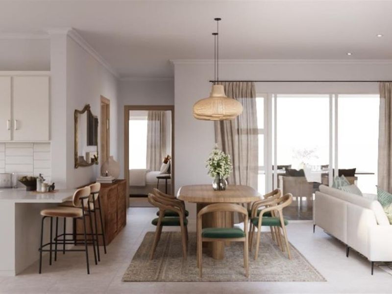 Modern open-plan living area featuring a sleek kitchen with built-in appliances, a dining space, and seamless access to the outdoor patio through sliding doors.