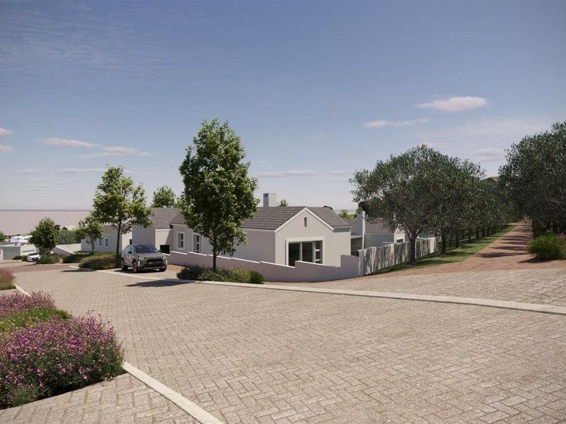 A high-angle view of a modern residential property featuring a paved driveway, boundary walls, and a tiled roof in a landscaped estate setting.