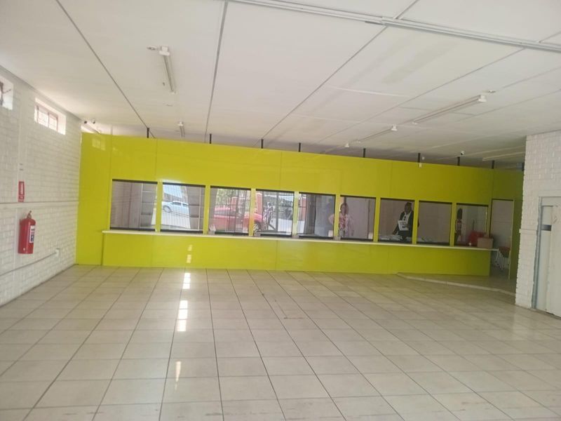 Open-plan commercial office space featuring a service counter, tiled flooring, and suspended ceiling, suitable for retail or administrative use.