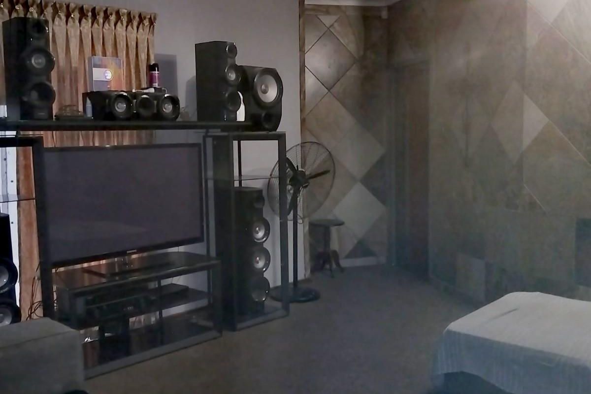 A living room featuring a tiled accent wall and neutral flooring, providing a functional space for entertainment and relaxation.