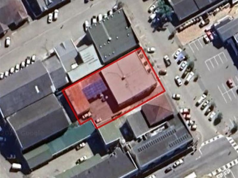 Aerial view of the commercial property highlighting the building footprint and roof structure within the urban context.