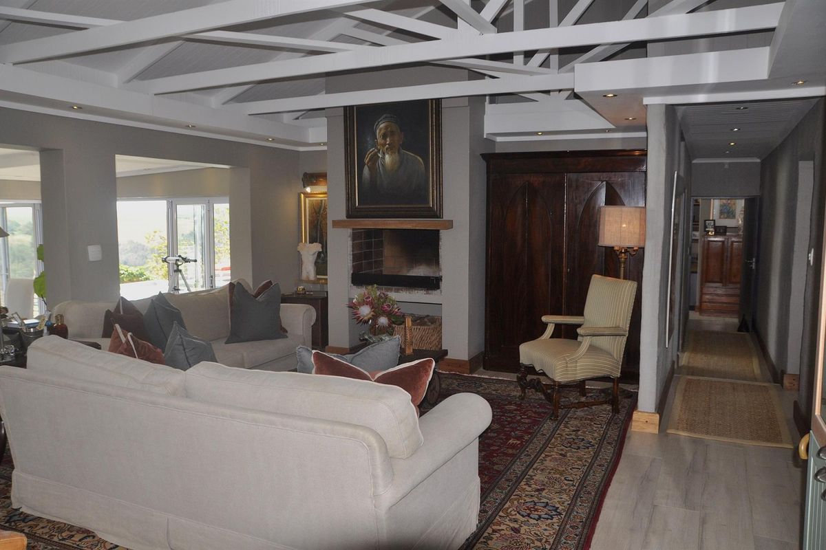 Spacious living room featuring a central fireplace, exposed white timber ceiling beams, and recessed lighting, creating a warm and inviting atmosphere.