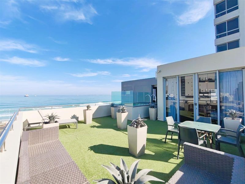 Spacious rooftop terrace featuring artificial turf, glass balustrades, and a private plunge pool with panoramic ocean views.