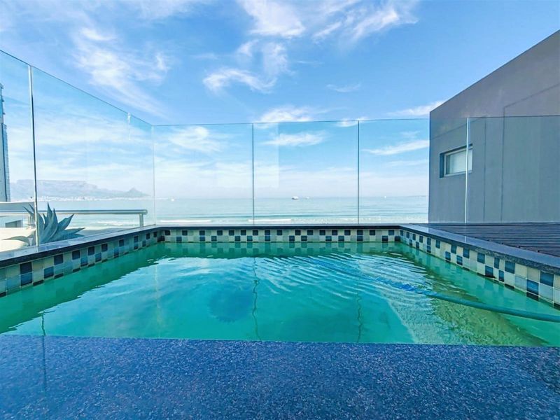 A private plunge pool featuring a glass balustrade, offering panoramic ocean views from the apartment terrace.