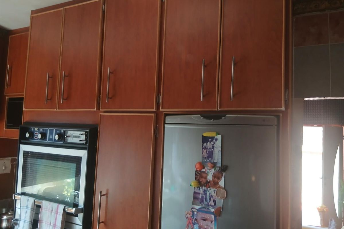 A kitchen area featuring wood-finish built-in cabinetry and a built-in oven unit.